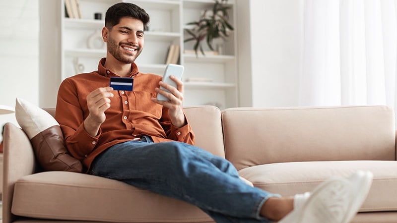 young man holding card and phone